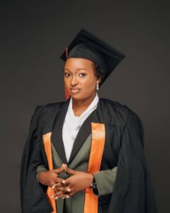 A young woman proudly poses in her graduation attire after receiving her degree in civil engineering